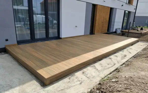 Nowe wykończenie deski kompozytowej tworzy elegancką przestrzeń przy nowoczesnym domu.